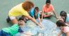 Kids and counselor drawing with chalk on ground