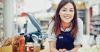 Young woman at checkout counter at store