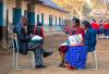 tanzanian men and women talking next to school