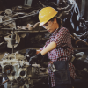 woman in hardhat working on large machinery